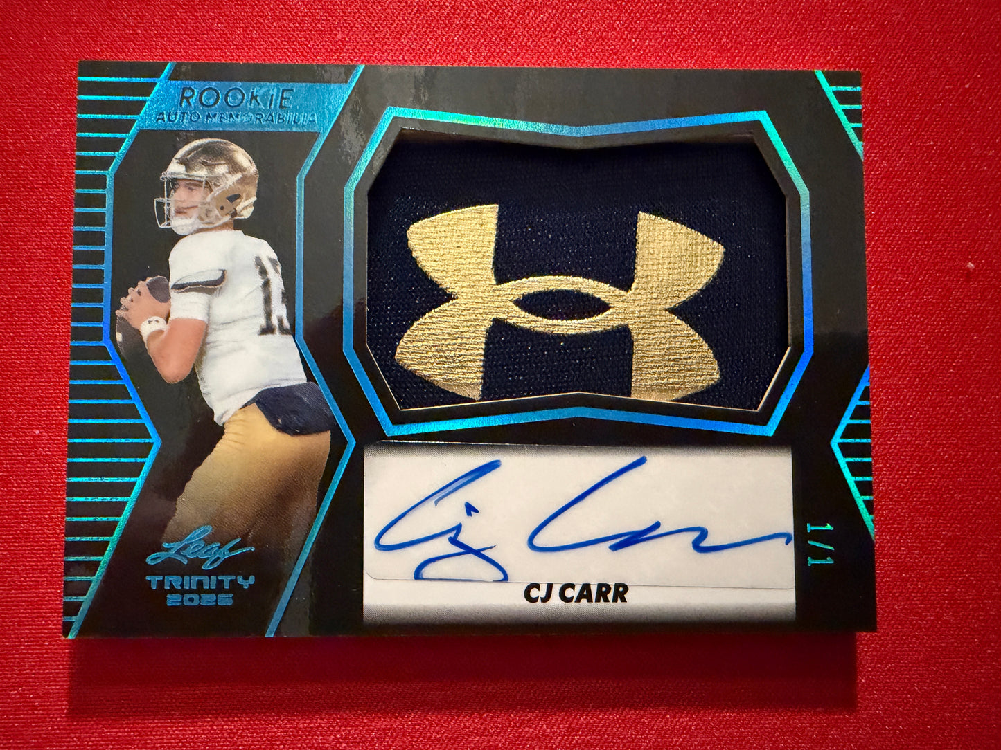 CJ Carr 2026 Leaf Trinity Rookie Auto Mem Black Gold Under Armor Logo Patch 1/1